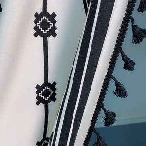 Cortina bohemia de algodón y lino con estampado geométrico negro y detalles de flecos