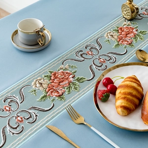 Light blue embroidered table runner with floral rose patterns and vintage scrolls