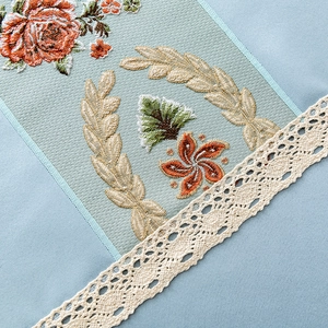 Elegant light blue tablecloth with rose embroidery and white lace edges in vintage style