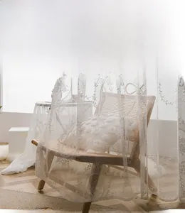 Close-up of white lace curtain with floral embroidery details and elegant wavy edges