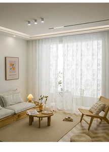 Close-up of white lace curtain featuring delicate floral embroidery and ruffled wavy edges
