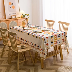 Bohemian geometric tablecloth with cotton linen texture and fringe on dining table