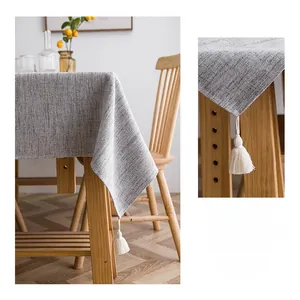 Detail view of grey cotton linen tablecloth showing fabric texture and white cotton tassels
