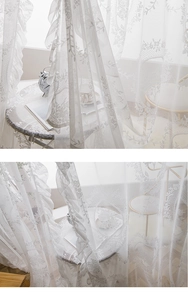Close-up of white lace curtain showing floral mesh pattern and ruffled edge detail