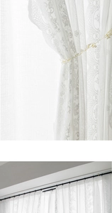 Detailed macro view of white lace floral embroidery and sheer curtain fabric layers