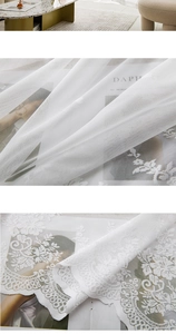 Detail of white lace curtain with intricate floral mesh and scalloped edges for window