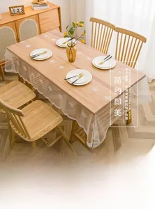 Gros plan sur la nappe en dentelle blanche avec broderie de flocons sur table en bois