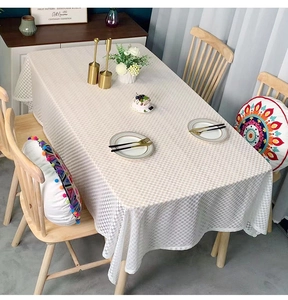 Detail of checkered rectangle tablecloth in cream and brown with soft fabric drape
