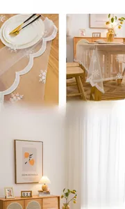 Détail d'une nappe en dentelle blanche avec broderie de flocons et bords ondulés