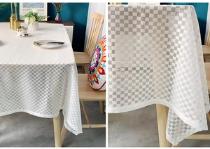 Detail showing white checkerboard pattern tablecloth with translucent texture on wood table