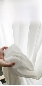 Close-up of white lace sheer curtain featuring elegant plum blossom hollow knit patterns