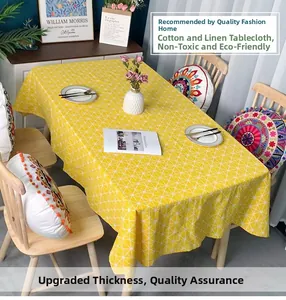 Detailed macro shot of yellow linen tablecloth with white geometric grid pattern on a wooden table