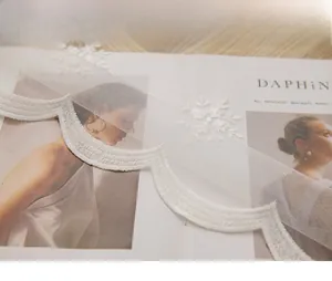 Détail de la nappe en dentelle blanche avec broderie flocon et bordure festonnée élégante