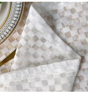 Close-up of white checkerboard mesh tablecloth with delicate woven texture and sheer fabric