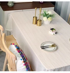 Detail of checkered cream tablecloth showing high-quality fabric texture and elegant drape