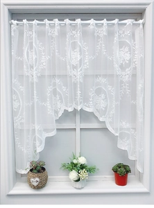 Detail of white lace cafe curtain with floral embroidery and elegant scalloped edge design