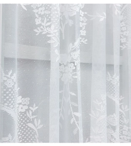 Close-up of white lace curtain with intricate floral patterns and sheer mesh texture