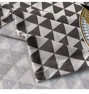 Close-up of geometric triangle pattern fabric with durable hemmed edge and linen texture