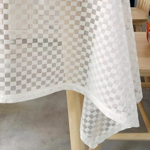 Minimalist white checkerboard tablecloth with a breathable mesh texture on wood