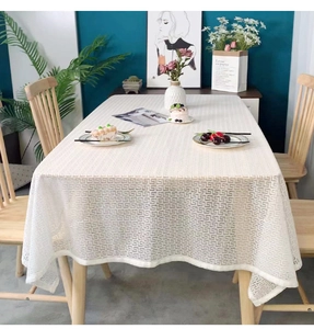 Close-up of white lace tablecloth featuring a geometric Greek Key hollow pattern design