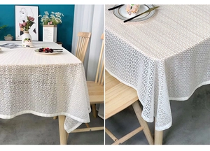 Detail of white jacquard tablecloth with Greek key pattern and lace texture