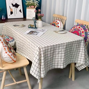Modern black and white plaid rectangular tablecloth in a cozy Nordic home dining setting