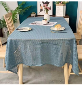 Close-up of blue geometric fret pattern tablecloth with mesh texture on wooden table