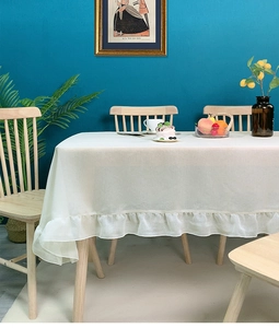 Close-up of cream ruffled edge tablecloth with elegant drape for rectangular tables