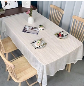 Close-up of a white rectangular tablecloth featuring a modern geometric mesh texture