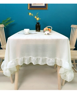 Close-up of a white Nordic minimalist tablecloth featuring elegant ruffled edges