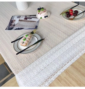 Detailed macro view of off-white geometric pattern tablecloth on a wooden table