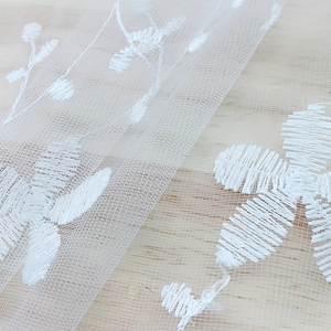 Nordic minimalist white lace mesh tablecloth with floral embroidery on wooden surface