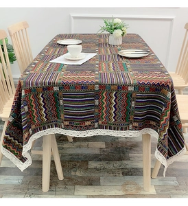 Close-up of bohemian geometric woven tablecloth featuring white crochet lace edge detail