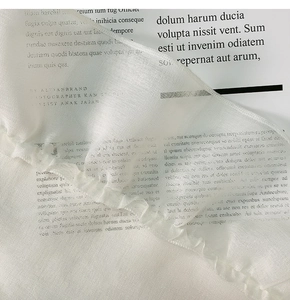 Macro shot of white semi-transparent gauze tablecloth with pleated ruffles on a magazine