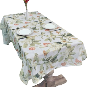 Floral print linen tablecloth with yellow flowers and green leaves on cream fabric
