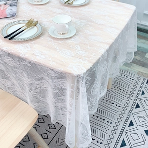 Nordic white lace tablecloth with floral hollow patterns on a wooden dining table