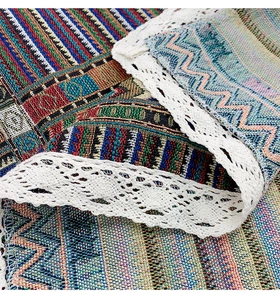 Close-up of ethnic woven pattern tablecloth with elegant white lace border detail