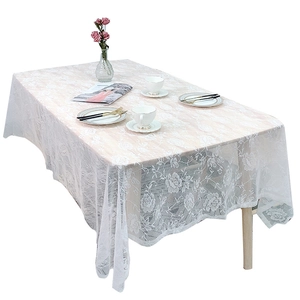 Elegant white lace tablecloth with rose hollow patterns on a rectangular dining table