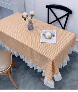 Detail showing orange gingham tablecloth with elegant white ruffled lace edge