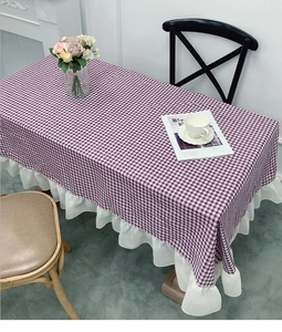 Detailed view of purple plaid tablecloth featuring elegant white ruffled lace edges
