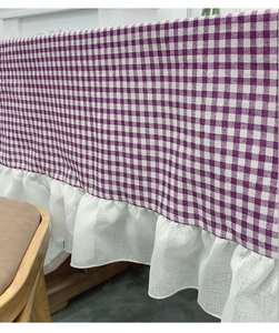 Detail of purple gingham tablecloth featuring white cotton linen ruffled lace edges