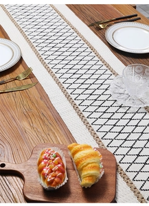 Detail of bohemian cotton linen table runner with geometric diamond patterns and tassels
