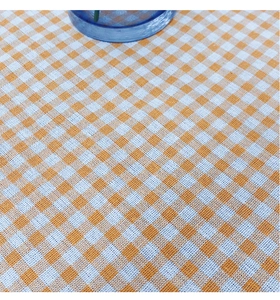 Close-up of orange and white gingham tablecloth with thick fabric texture and lace edge