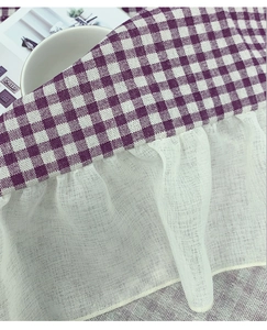 Detailed close-up of purple gingham tablecloth with white lace ruffle edge trimming