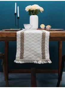 Detailed texture of two-tone woven cotton linen table runner with elegant tassels