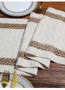 Detail of bohemian woven table runner with beige cotton linen and brown hollow patterns