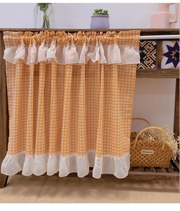 Detail of yellow checkered cafe curtain with white lace ruffles and linen texture