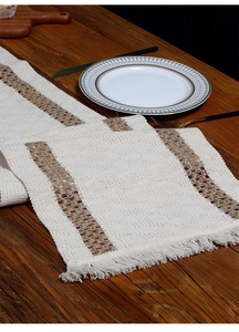 Detailed view of woven cotton linen table runner with tassels and hollow bohemian patterns