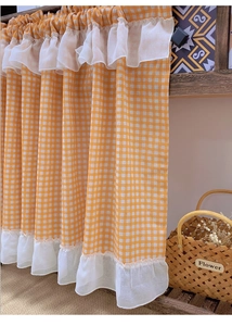 Detail of orange and white checkered cafe curtain with delicate double-layered ruffled edges