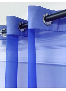 Detail of blue outdoor sheer curtain with silver grommets and dual-texture fabric finish